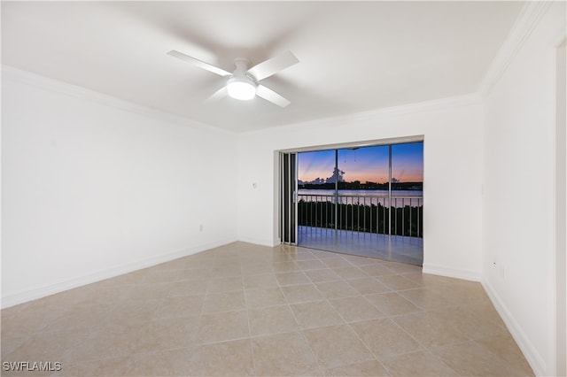 spare room with ceiling fan, crown molding, and light tile patterned floors