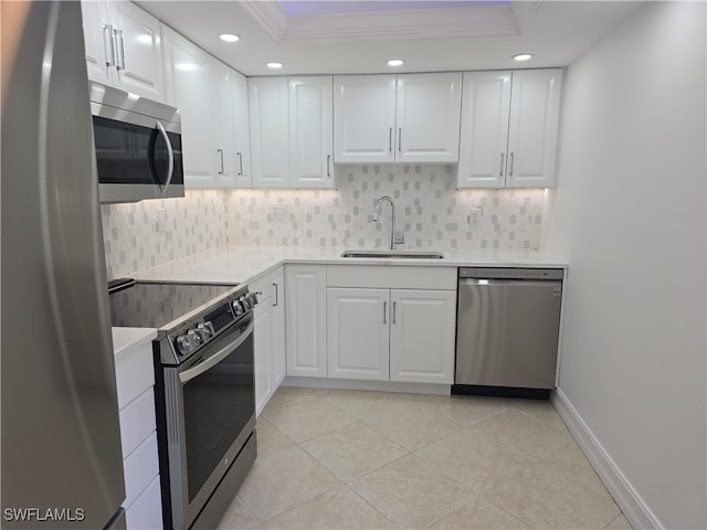 kitchen featuring sink, stainless steel appliances, backsplash, white cabinets, and ornamental molding