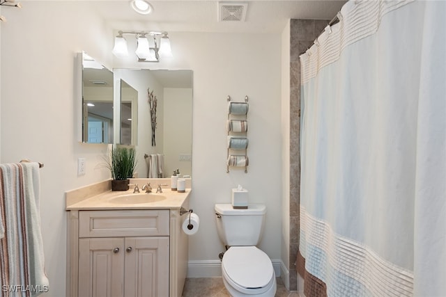 bathroom with tile patterned flooring, vanity, and toilet