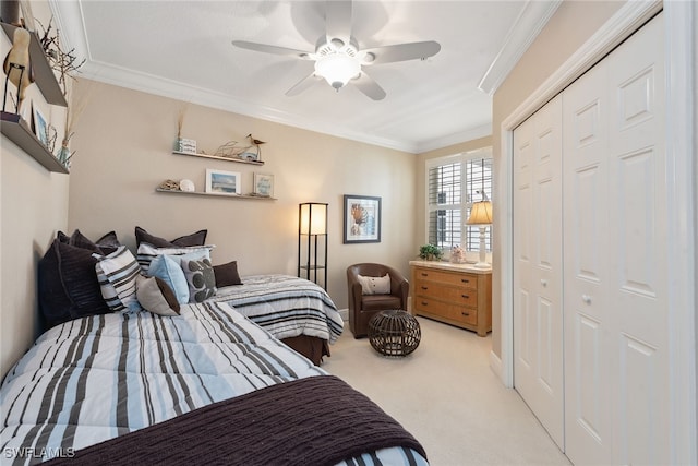 carpeted bedroom with ceiling fan, crown molding, and a closet