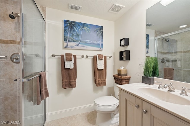 bathroom with walk in shower, vanity, a textured ceiling, tile patterned flooring, and toilet