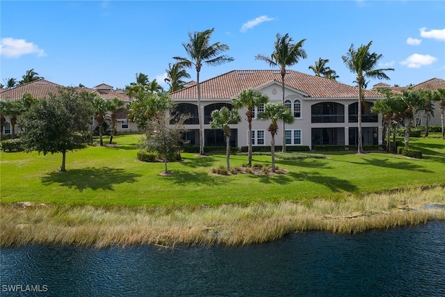 back of house featuring a lawn and a water view