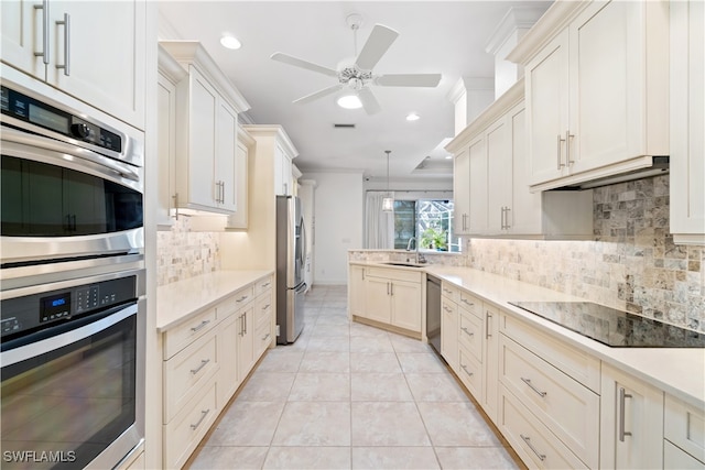 kitchen with ornamental molding, appliances with stainless steel finishes, light tile patterned floors, decorative backsplash, and sink