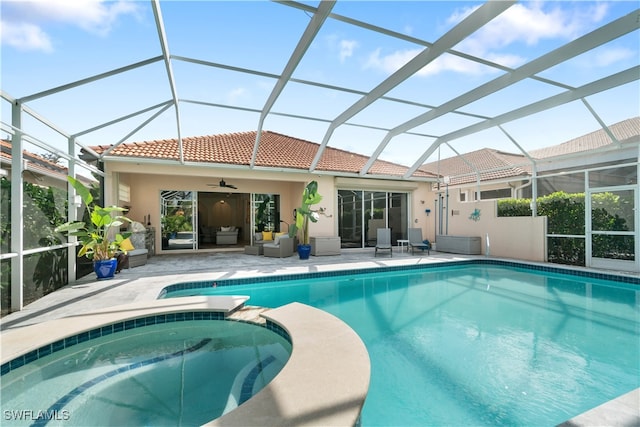 view of swimming pool with a lanai, ceiling fan, a patio, and an in ground hot tub