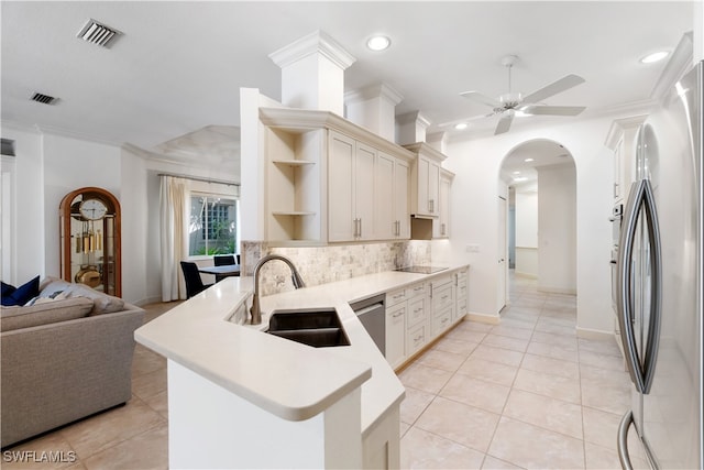 kitchen with light tile patterned flooring, appliances with stainless steel finishes, decorative backsplash, sink, and kitchen peninsula