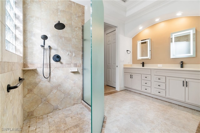 bathroom featuring vanity, a healthy amount of sunlight, a tile shower, and crown molding