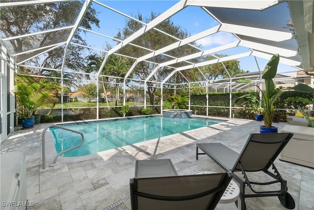 view of pool featuring glass enclosure, a patio area, and an in ground hot tub