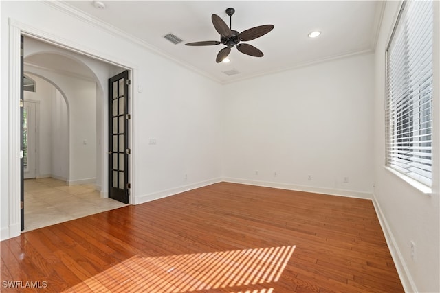 spare room with a healthy amount of sunlight, light hardwood / wood-style flooring, and ornamental molding