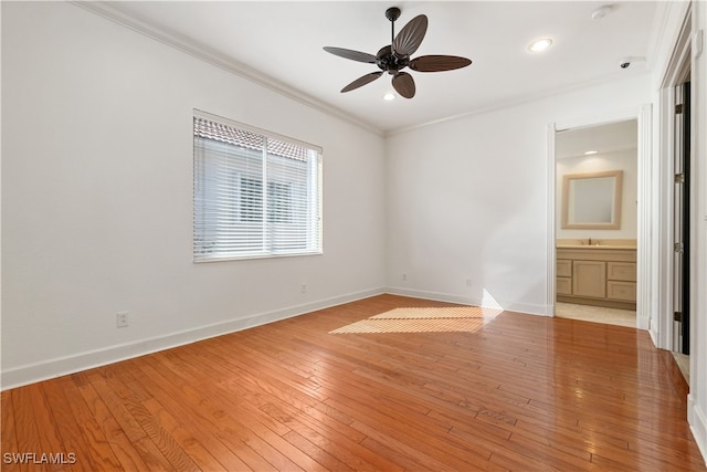 unfurnished bedroom featuring crown molding, light hardwood / wood-style flooring, ceiling fan, and ensuite bath