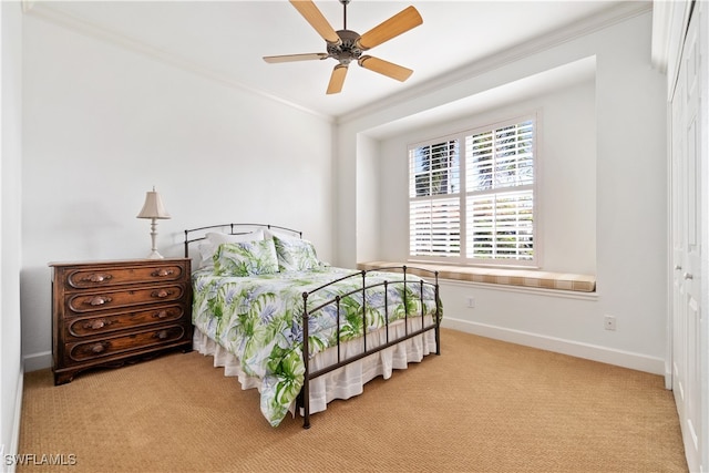 carpeted bedroom with ceiling fan, crown molding, and a closet