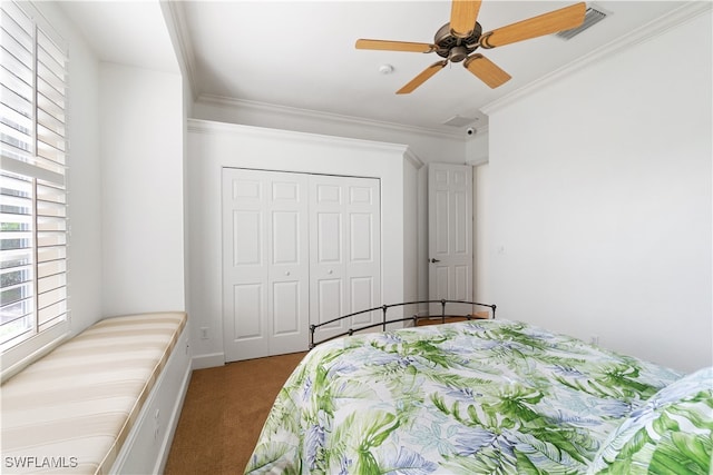 carpeted bedroom with ornamental molding, ceiling fan, and a closet