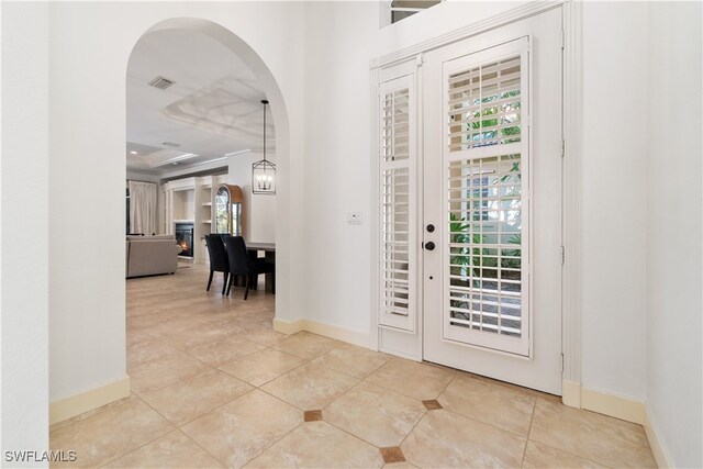 foyer entrance with a chandelier and tile patterned flooring