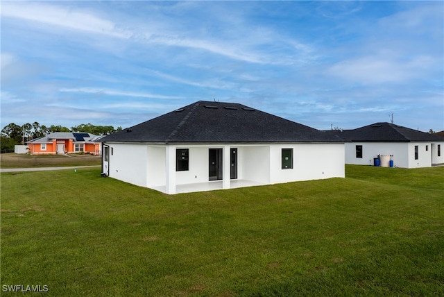 rear view of house featuring a patio area and a lawn