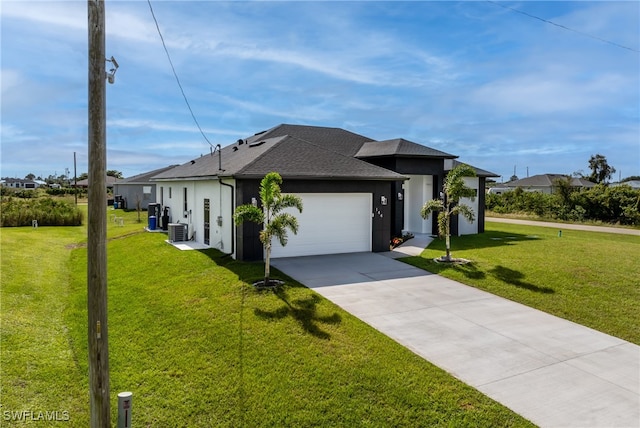 view of front of house featuring a garage, a front lawn, and central air condition unit