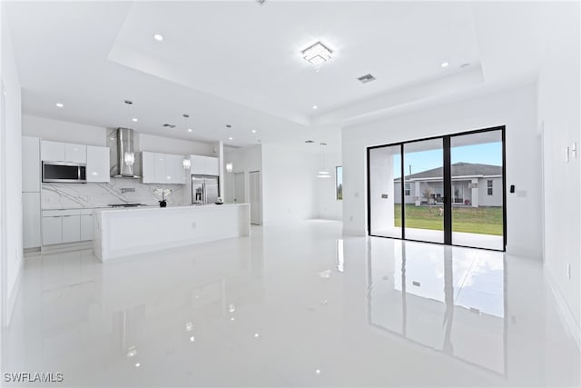 unfurnished living room featuring a raised ceiling