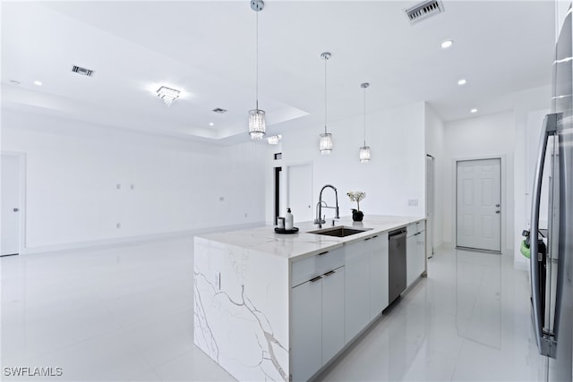 kitchen featuring sink, white cabinetry, pendant lighting, stainless steel dishwasher, and a kitchen island with sink