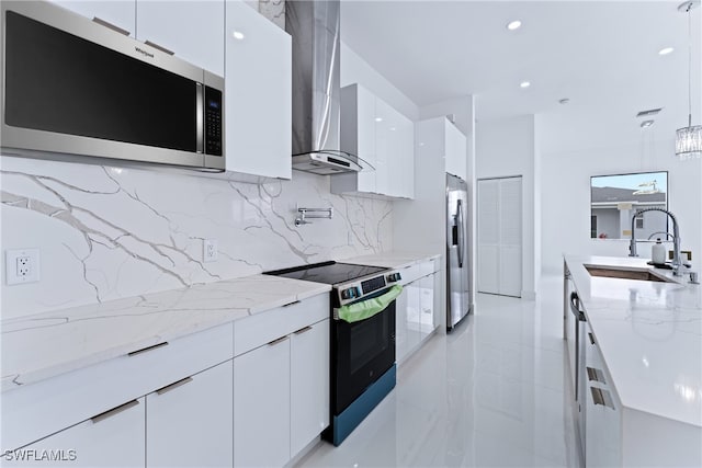 kitchen featuring tasteful backsplash, sink, white cabinetry, stainless steel appliances, and pendant lighting