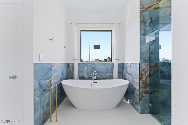 bathroom featuring tile patterned flooring, tile walls, and separate shower and tub