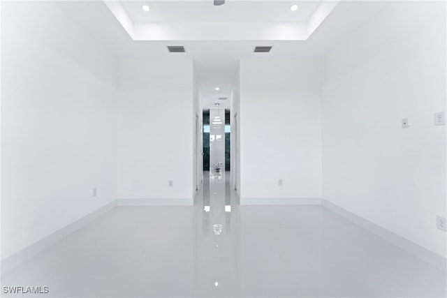 empty room featuring concrete floors and a raised ceiling