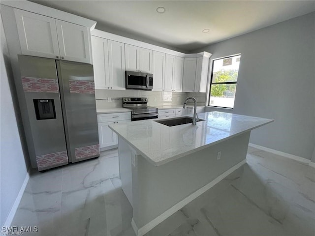 kitchen with white cabinetry, light stone counters, and appliances with stainless steel finishes