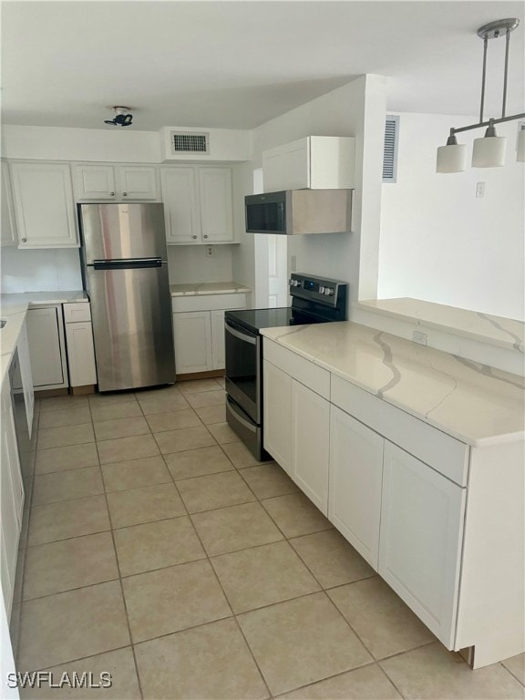 kitchen featuring stainless steel appliances, light tile patterned flooring, white cabinets, and pendant lighting