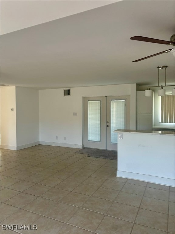 tiled spare room featuring french doors and ceiling fan