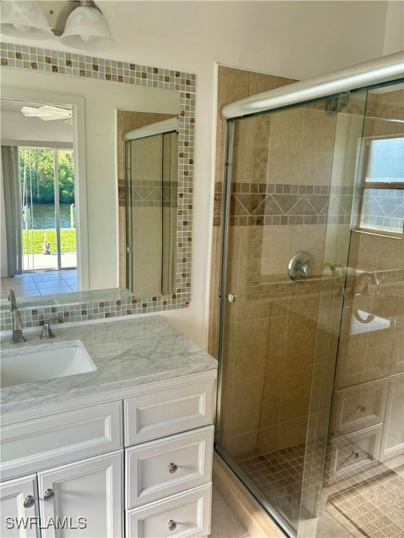 bathroom with an enclosed shower, vanity, and a water view