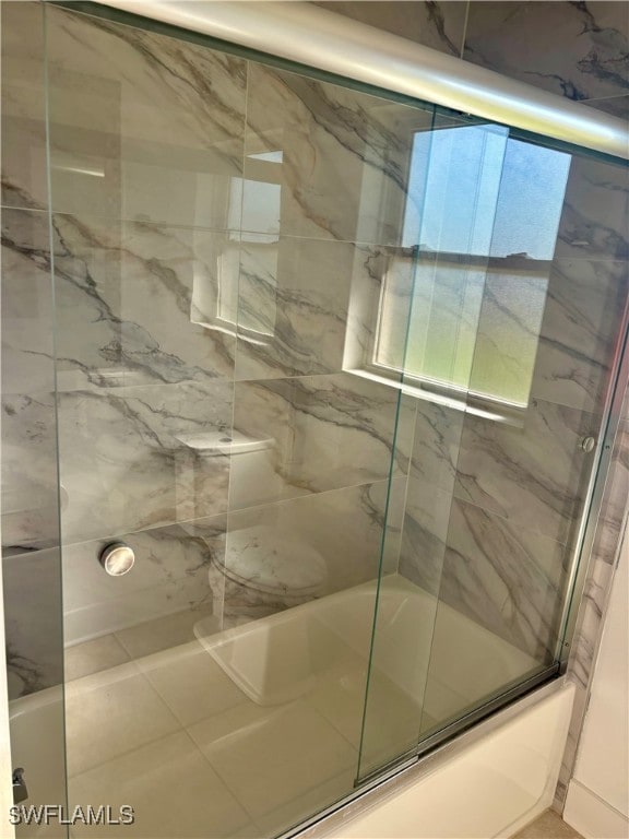 bathroom with shower / bath combination with glass door