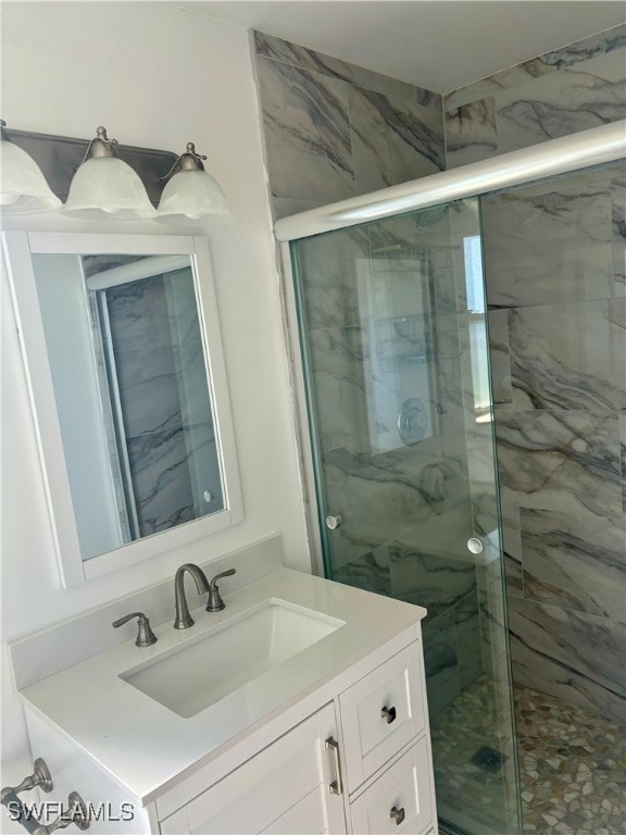 bathroom featuring vanity and a shower with door