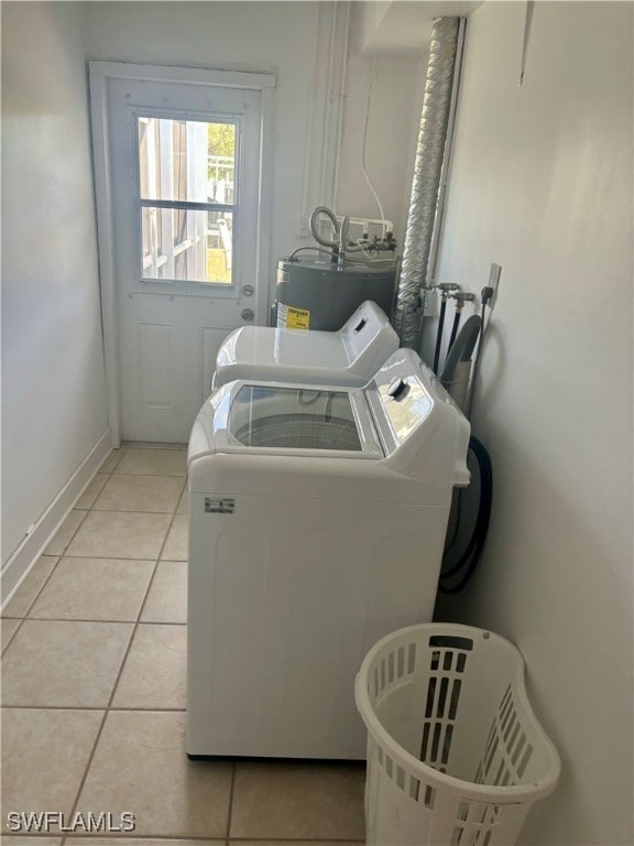 laundry room featuring light tile patterned flooring, water heater, and washing machine and dryer