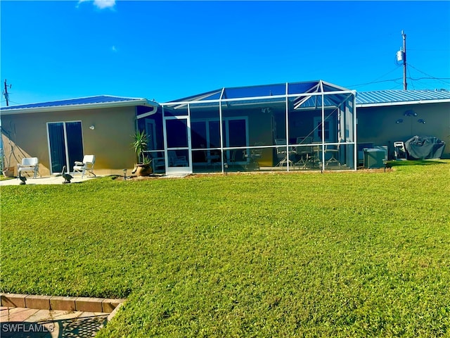 back of property featuring a lanai and a yard