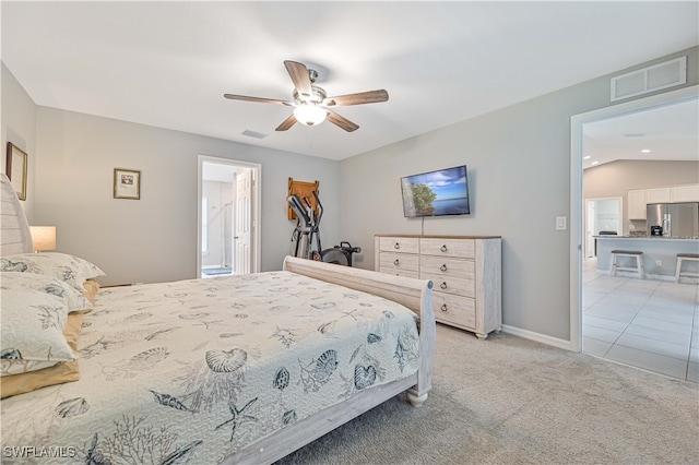 bedroom with vaulted ceiling, ceiling fan, stainless steel refrigerator with ice dispenser, light carpet, and ensuite bath