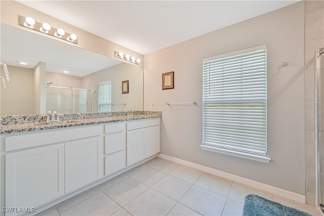 bathroom with an enclosed shower, vanity, and tile patterned floors