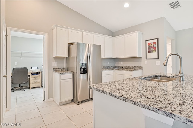 kitchen with white cabinetry, sink, stainless steel fridge, and light stone countertops