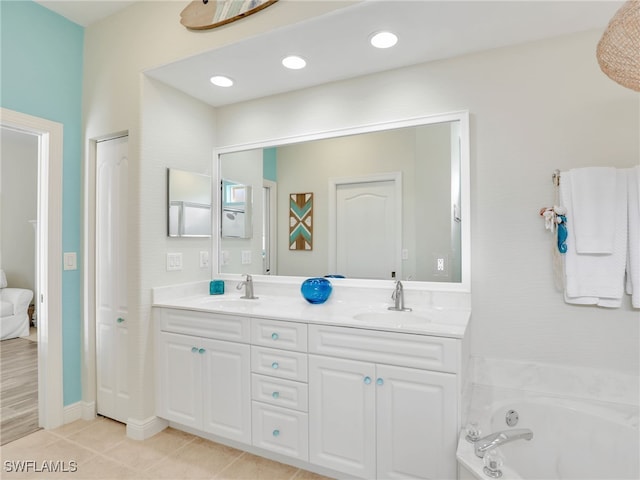 bathroom featuring tile patterned flooring, a bath, and vanity