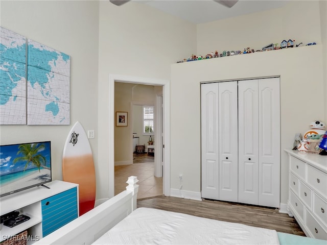 bedroom with hardwood / wood-style flooring, ceiling fan, and a closet