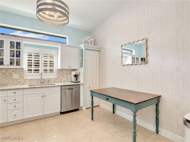 kitchen featuring a wealth of natural light, dishwasher, sink, and white cabinets