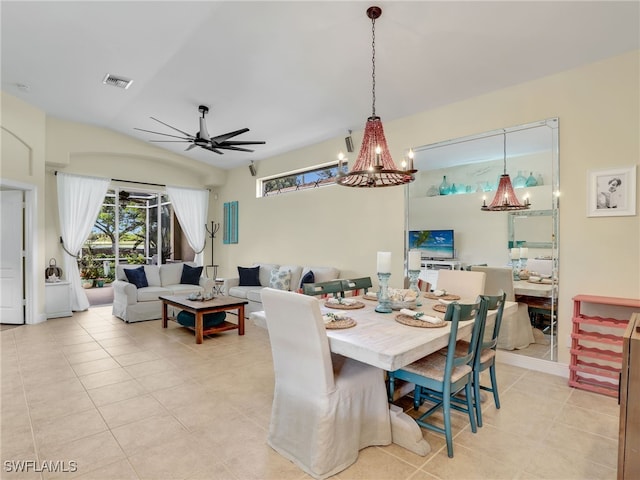 dining space featuring lofted ceiling, light tile patterned floors, and ceiling fan with notable chandelier