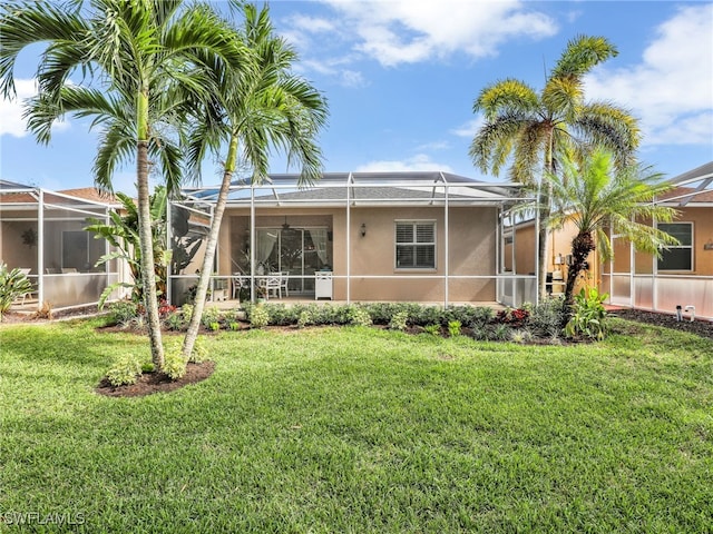 back of property featuring glass enclosure and a yard