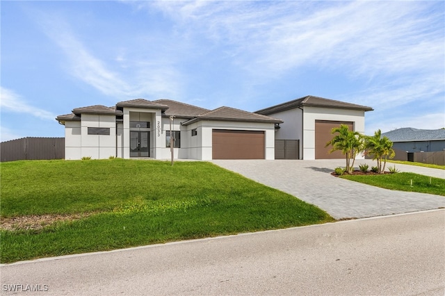 prairie-style home with a garage and a front lawn