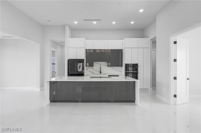 kitchen with backsplash, a spacious island, white cabinetry, and black appliances