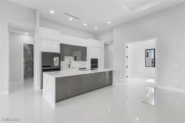 kitchen featuring white cabinets, black appliances, sink, and a spacious island