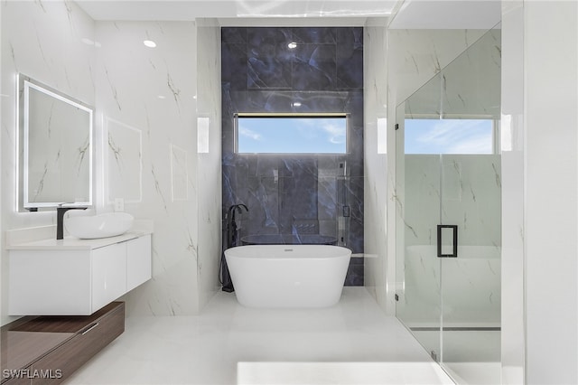 bathroom with tile walls, shower with separate bathtub, and vanity