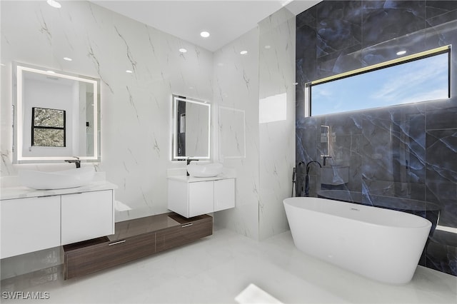 bathroom with vanity, tile walls, and a tub