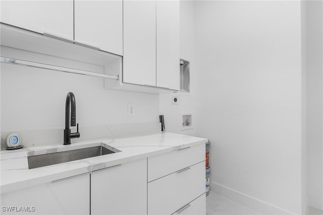 laundry area with cabinets, washer hookup, hookup for an electric dryer, and sink