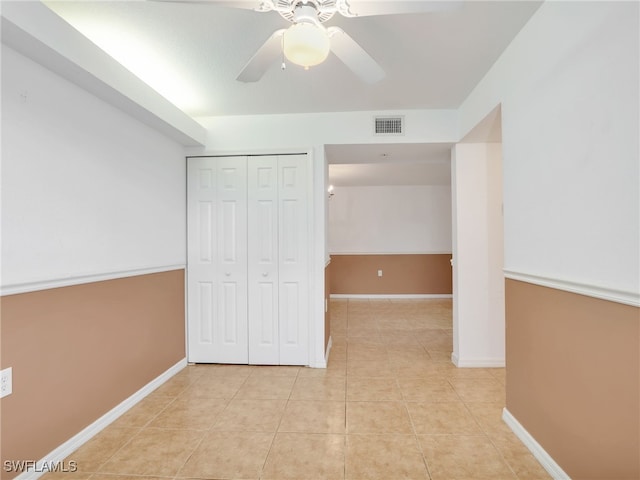 unfurnished bedroom featuring ceiling fan, a closet, and light tile patterned flooring