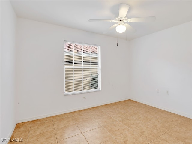 tiled spare room with ceiling fan