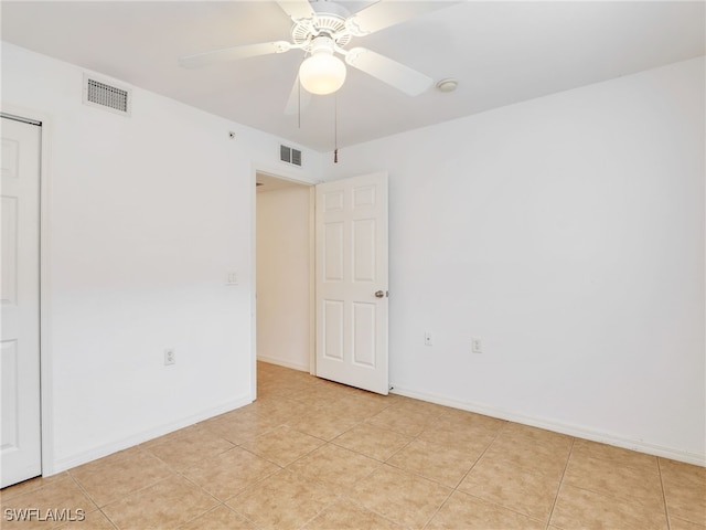 tiled spare room with ceiling fan