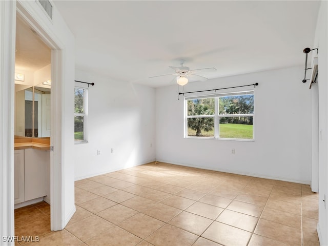 tiled spare room featuring ceiling fan