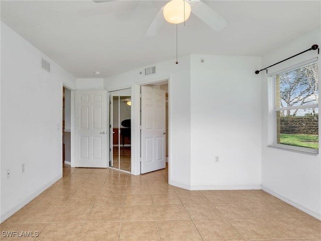 tiled empty room with ceiling fan